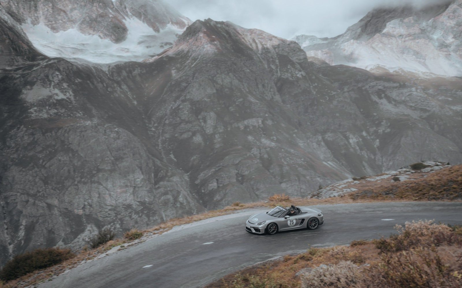 Silver Porsche on a misty mountain road
