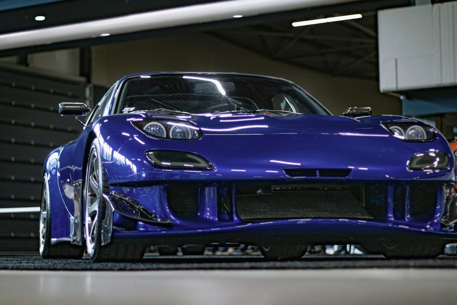 Deep blue Mazda RX-7 in an indoor hall