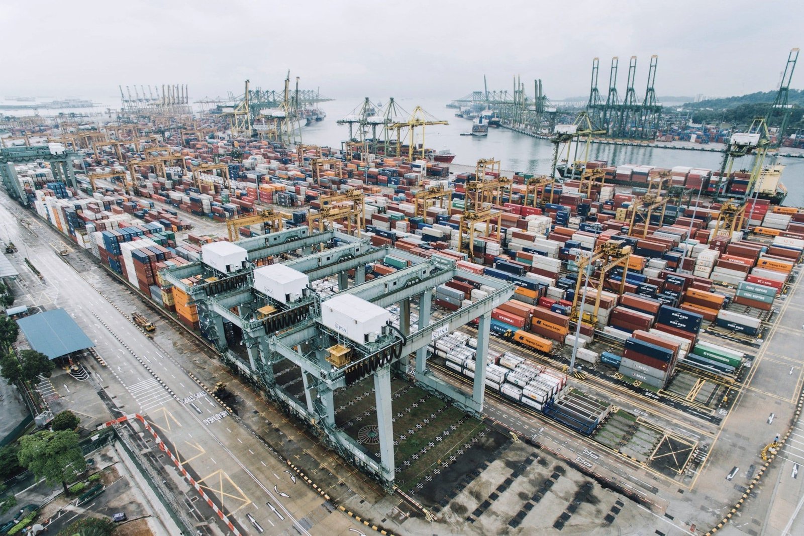 Container cranes loading a ship at a busy port