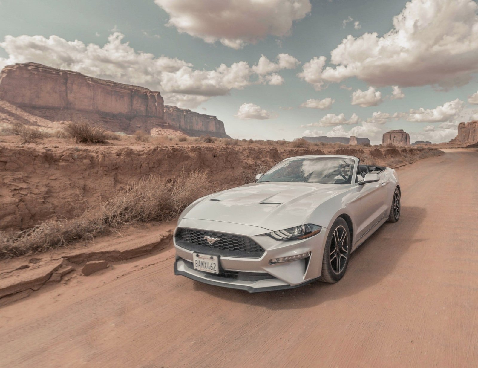 Ford Mustang convertible among desert mesas